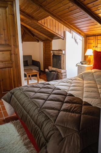 a bedroom with a large bed and a fireplace at Villa Virginia Hotel in Karpenision
