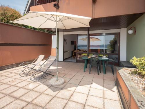 a patio with a table and chairs and an umbrella at Apartment Norby by Interhome in Ghiffa