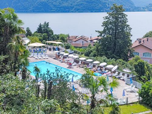 a resort swimming pool with a view of a lake at Apartment Norby by Interhome in Ghiffa