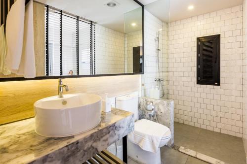 a bathroom with a sink and a mirror at Snoozz Hotel Krabi in Krabi town
