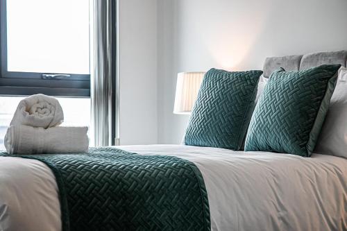 a bed with green and white sheets and a window at iQuarter Apartment - City Centre - Free Secure Parking, Self-Check-In, Fast Wifi and Smart TV by Yoko Property in Sheffield