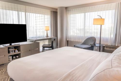 a hotel room with a bed and a flat screen tv at Orange County Hotel in Santa Ana