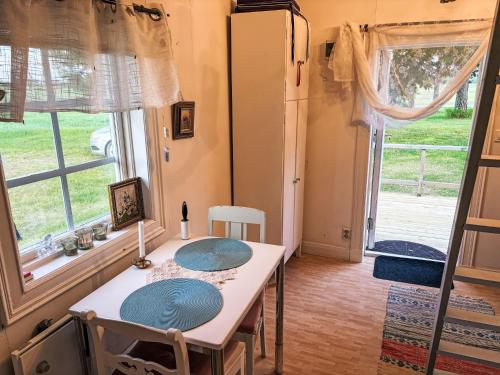 a dining room with a table and a large window at Holiday Home Skyberga Torp Lilla stugan by Interhome in Kumla