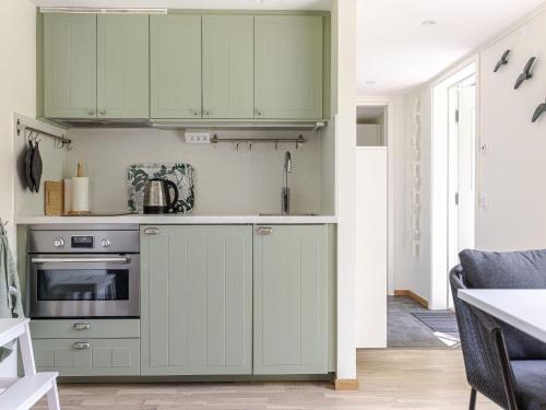 a kitchen with green cabinets and a stove at Holiday Home Särdals Lycke by Interhome in Steninge