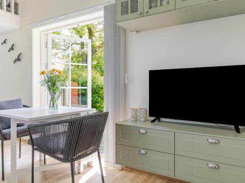 a living room with a tv and a table with chairs at Holiday Home Särdals Lycke by Interhome in Steninge