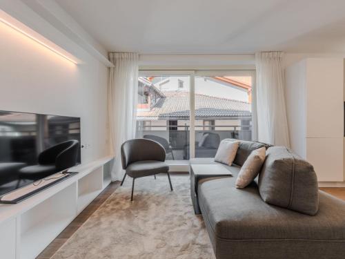 a living room with a couch and a large window at Apartment Olga by Interhome in Pinzolo