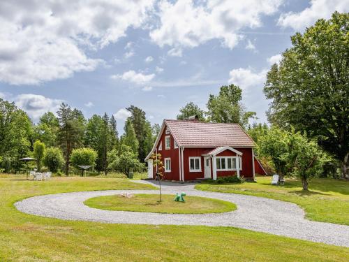 a small red house with a winding road in front at Holiday Home Skogstorp Ledja by Interhome in Holmsjö