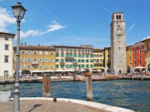 a group of buildings and a river with a clock tower at Apartment Boschetto by Interhome in Riva del Garda