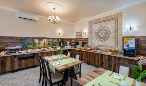 a restaurant with tables and chairs and a counter at Gosztola Gyöngye-az erdő szállodája in Gosztola
