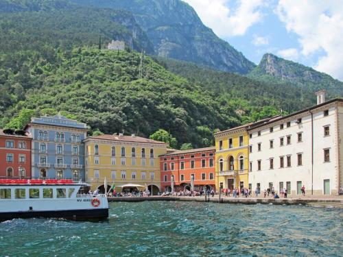 a boat in a body of water next to buildings at Apartment Boschetto by Interhome in Riva del Garda