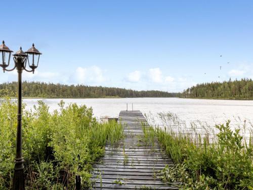 a wooden walkway over a lake with a street light at Holiday Home Jönsamåla by Interhome in Ryd
