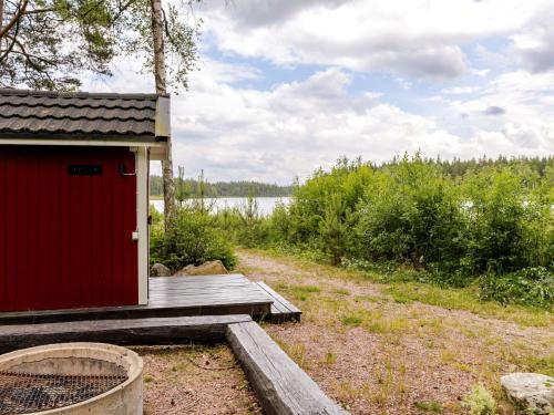 a red building on a dock next to a body of water at Holiday Home Jönsamåla by Interhome in Ryd