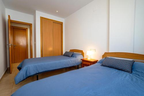 two beds in a room with blue sheets at Villamagna Pueblo Vidaber in Oropesa del Mar