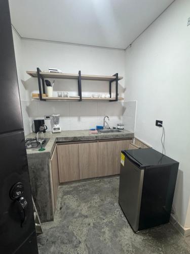 a small kitchen with a sink and a refrigerator at APARTAHOTEL DdKk in Cali