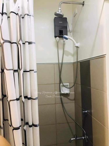 a shower in a bathroom with a shower curtain at Sky Suites at Spring Residences Condotel near NAIA and SM Bicutan Mall in Manila