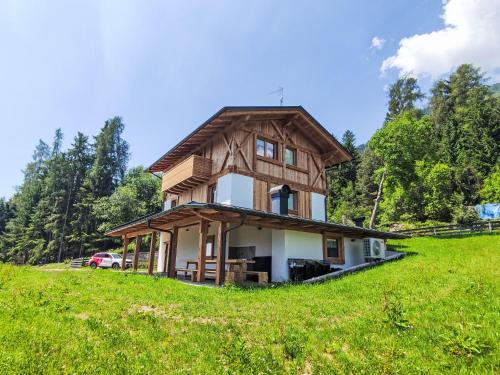 a house with a gambrel roof on a green hill at Apartment Larice Bilocale by Interhome in Livo