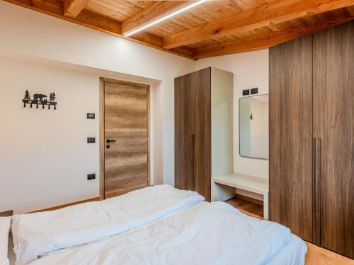 a bedroom with a bed and a wooden door at Apartment Larice Bilocale by Interhome in Livo