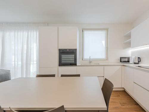 a white kitchen with a table and a window at Apartment Maria by Interhome in Pinzolo