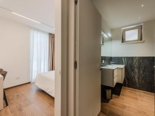 a bedroom with a bed and a bathroom with a sink at Apartment Maria by Interhome in Pinzolo
