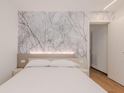 a bedroom with a white bed and trees mural at Apartment Maria by Interhome in Pinzolo