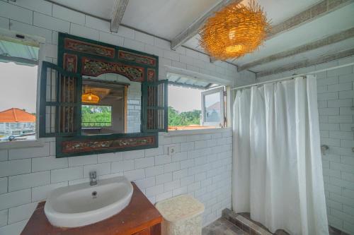 a bathroom with a sink and a mirror at The Sri Loft in Dalung