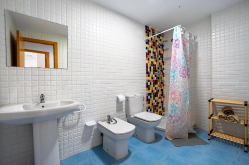 a bathroom with a sink and a toilet and a mirror at Villamagna Pueblo Vidaber in Oropesa del Mar