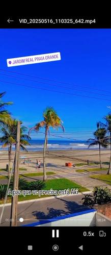 a screenshot of a picture of a beach with palm trees at Kitnet pé na areia in Praia Grande