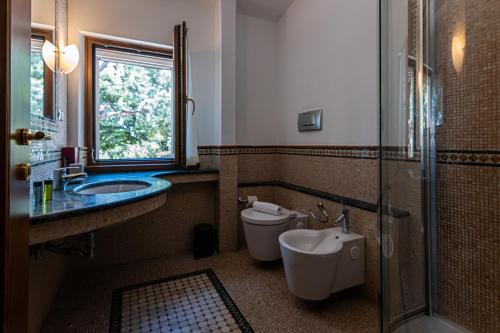 a bathroom with a toilet and a sink and a shower at La Ginestra in Fiore Camere in Sirolo