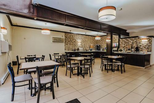 a restaurant with tables and chairs and a kitchen at SureStay Plus by Best Western Coquitlam in Coquitlam