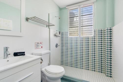 a white bathroom with a toilet and a shower at Cozy Apartment with High Ceilings and Panoramic Views in Miramar in San Juan