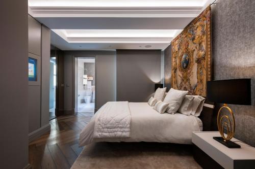 a bedroom with a bed with a large painting on the wall at Lux Top Floor in the Hearth of Valletta by Arco Collection in Valletta