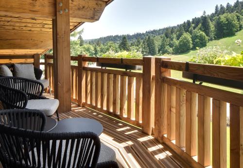 a deck with chairs and a view of the mountains at Domaine de Montagne - Hôtel Chalet Frère Joseph in Ventron