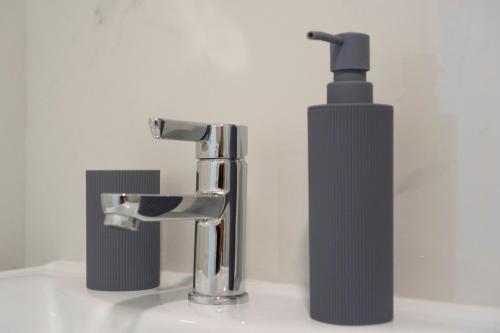 a sink with a faucet and a soap dispenser at Apartman Petra Trebinje in Trebinje