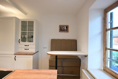 a kitchen with a table and a chair next to a window at Charmante Altbauwohnung mit Flair in Polling in Polling
