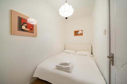 a white bed in a room with a picture on the wall at Tonight Homestay West Nanjing Road Branch Shanghai in Shanghai