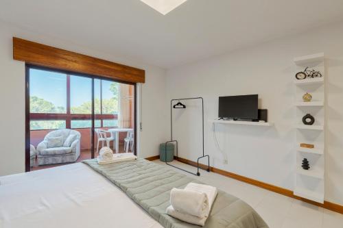 a bedroom with a large bed and a television at Regina Beach House - By Y Concept in Costa da Caparica