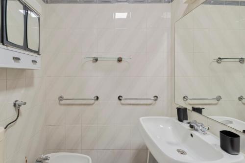 a white bathroom with a sink and a toilet at Regina Beach House - By Y Concept in Costa da Caparica