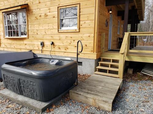 a large tub sitting in front of a cabin at Hickory Ridge - HotTub - GSMNP, NOC, Train and Fontana Lake in Almond