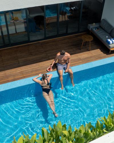 a man and woman playing in a swimming pool at Villa Mia Fulhadhoo in Fulhadhoo