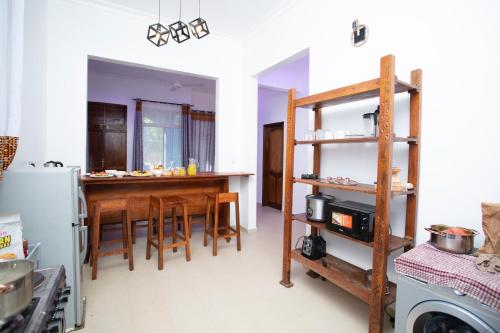 a kitchen with a table and chairs and a refrigerator at Michamvi Holiday Homes in Michamvi