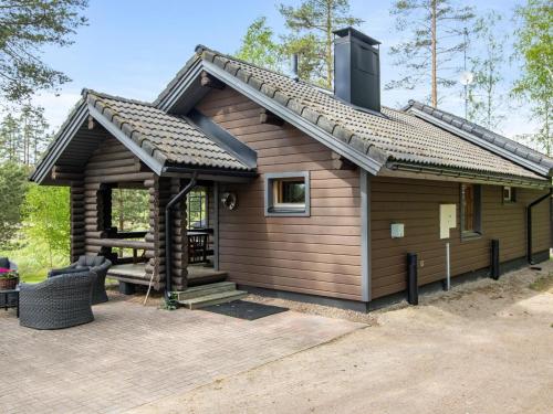 a log cabin with a porch and a patio at Holiday Home Mustijoki by Interhome in Savitaipale