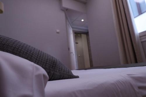 a bedroom with a bed with a pillow and a window at Hostal Victoria in Málaga