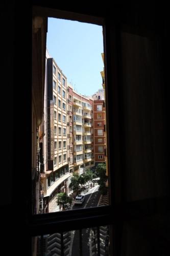 a view of a city from a window at Hostal Victoria in Málaga