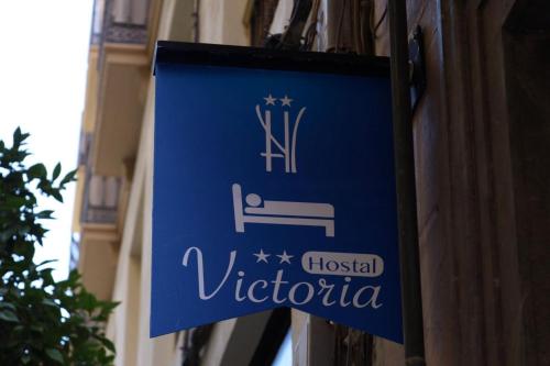 a sign for a hospital victoria on a building at Hostal Victoria in Málaga