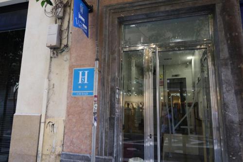 a door to a store with a blue sign on a building at Hostal Victoria in Málaga