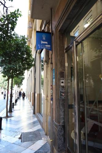 a sign on the side of a building on a street at Hostal Victoria in Málaga