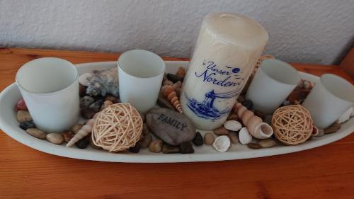 a plate of rocks and seashells and a bottle of milk at Ferienbucht Marina in Scharbeutz