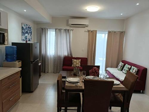 a kitchen and living room with a table and a couch at Cozy 2bedrooms Matina Enclaves condo in Davao City