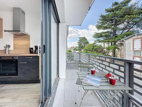 a patio with a table and a kitchen on a balcony at Apartment Océanide-2 by Interhome in La Bernerie-en-Retz