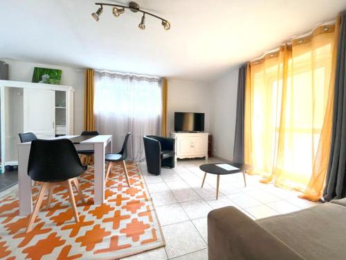 a living room with a table and chairs at Appartement avec terrasse dans un parc privé in Bégard